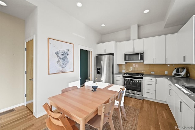 2004 Foxtail Ln Unit B, Lafayette, CO 80026 - kitchen featuring stainless steel appliances, light wood-type flooring, tasteful backsplash, white cabinetry, and recessed lighting
