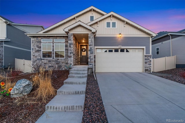 view of front of home with board and batten siding, an attached garage, driveway, and fence