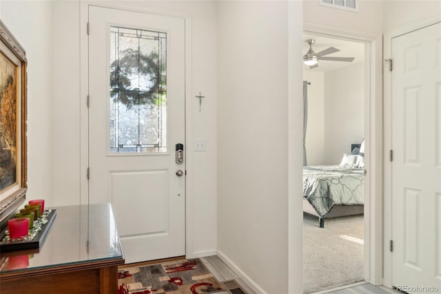 foyer entrance featuring visible vents and baseboards