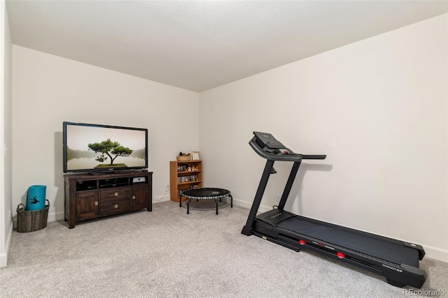 workout area featuring carpet and baseboards