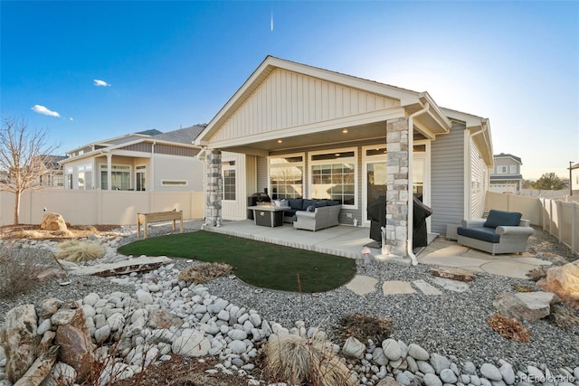 rear view of property featuring a patio area, outdoor lounge area, and a fenced backyard