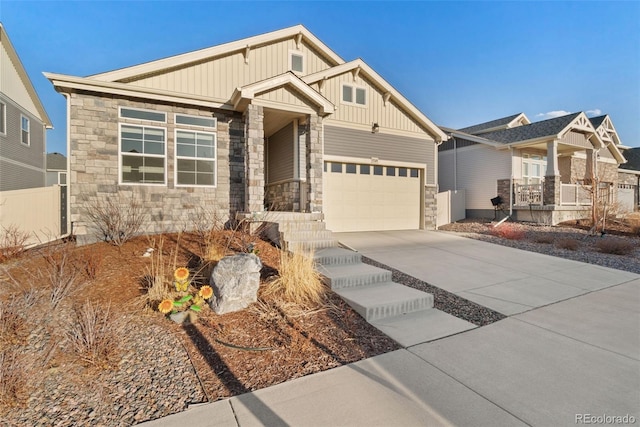 craftsman house with stone siding, fence, board and batten siding, concrete driveway, and a garage