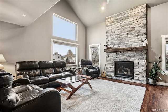 living room featuring high vaulted ceiling, dark wood finished floors, and a fireplace