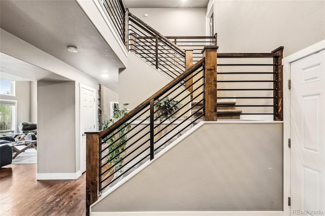 staircase featuring baseboards and wood finished floors