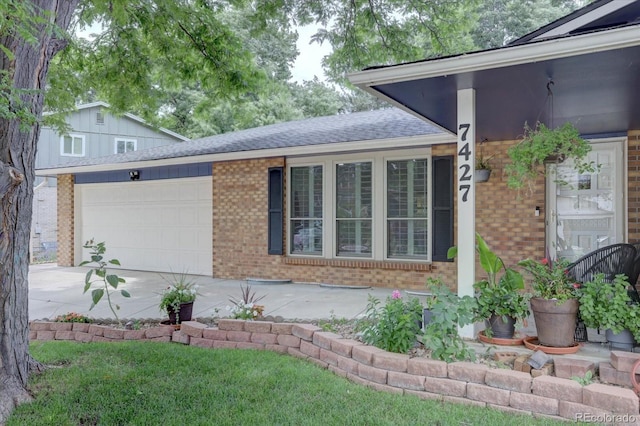7427 S Ames Ct, Littleton, CO 80128 - view of home's exterior featuring brick siding, driveway, an attached garage, and a shingled roof