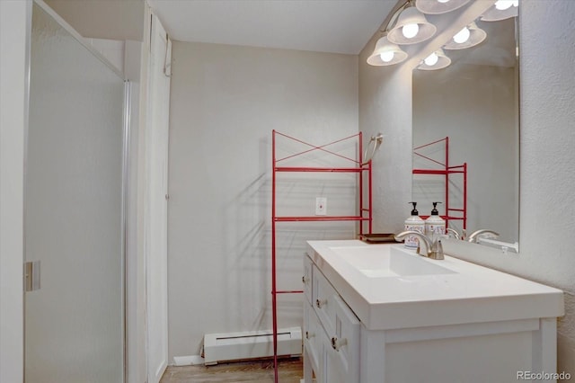 7427 S Ames Ct, Littleton, CO 80128 - bathroom featuring a baseboard heating unit, vanity, and wood finished floors