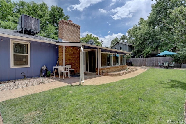 7427 S Ames Ct, Littleton, CO 80128 - back of property featuring a patio area, a chimney, and brick siding