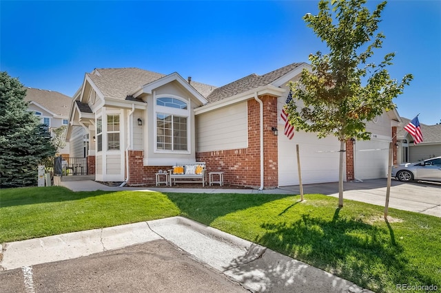 view of front of home featuring brick siding, driveway, a front lawn, and a garage