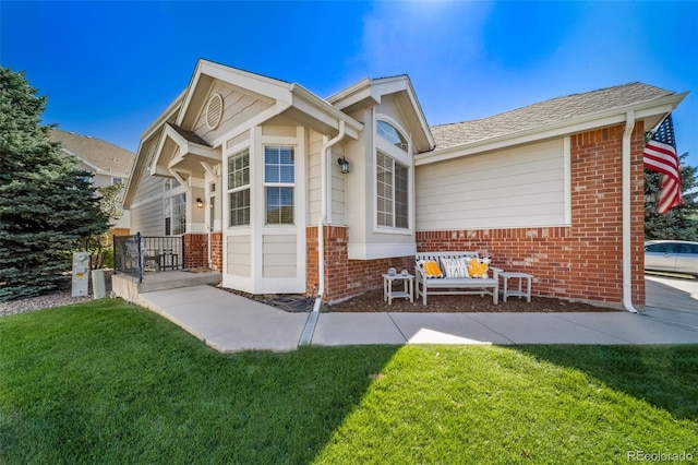 view of side of property featuring a yard and brick siding