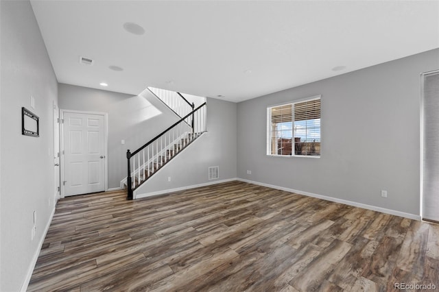 unfurnished living room with dark wood-type flooring