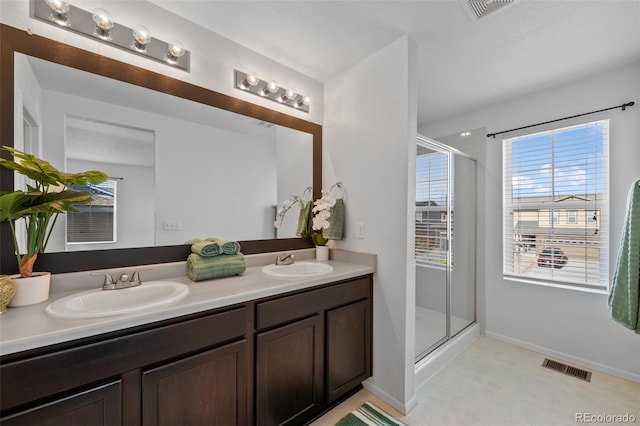 bathroom with a shower with door and vanity