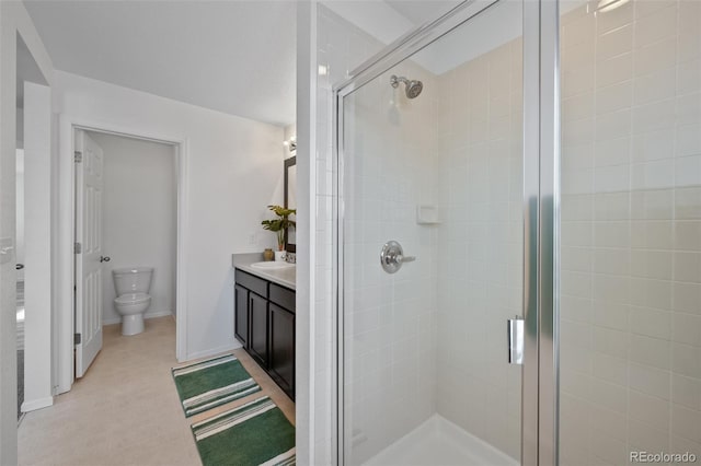 bathroom with vanity, toilet, and a shower with door