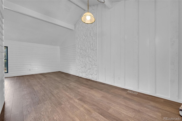 unfurnished room with vaulted ceiling with beams and wood-type flooring