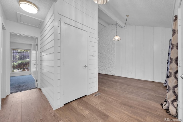 corridor with hardwood / wood-style floors and a textured ceiling