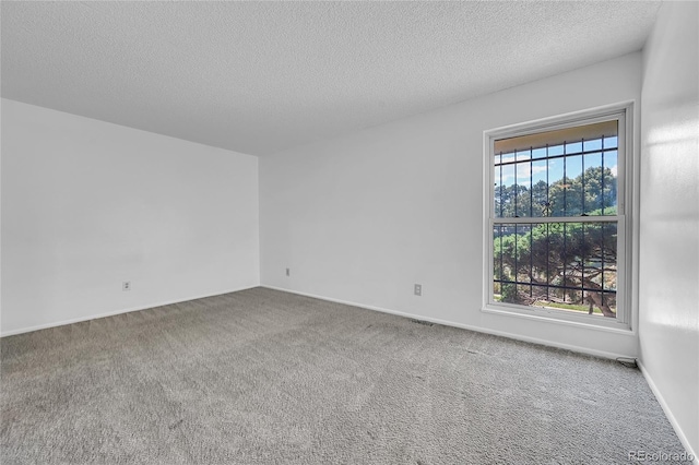 carpeted empty room with a textured ceiling