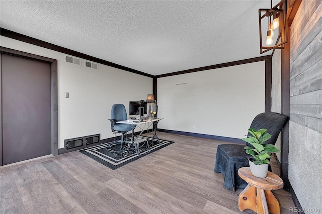 living area with ornamental molding, hardwood / wood-style floors, and a textured ceiling