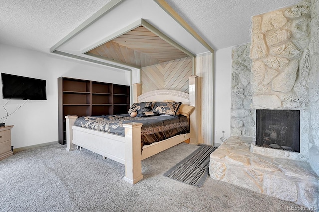 bedroom featuring a stone fireplace, carpet flooring, and a textured ceiling