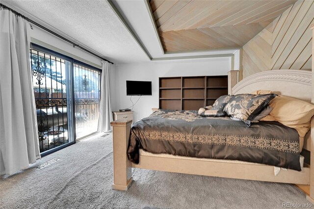 bedroom featuring access to exterior, a textured ceiling, and carpet