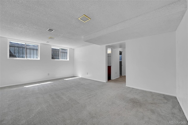 carpeted empty room with a textured ceiling