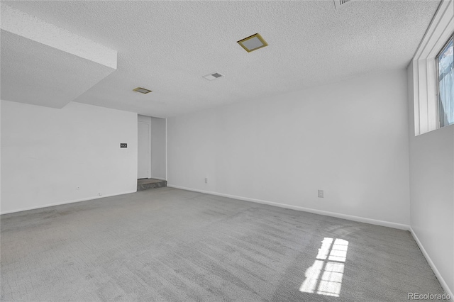 unfurnished room featuring carpet floors and a textured ceiling