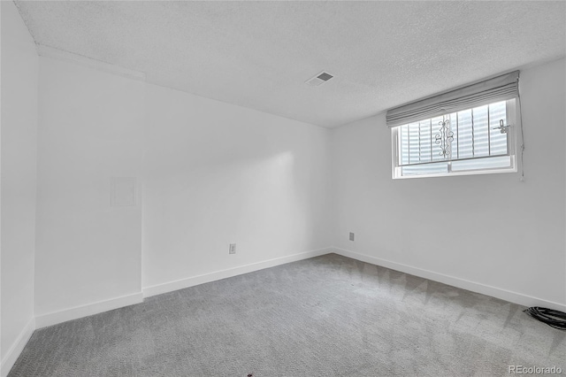 spare room featuring carpet floors and a textured ceiling