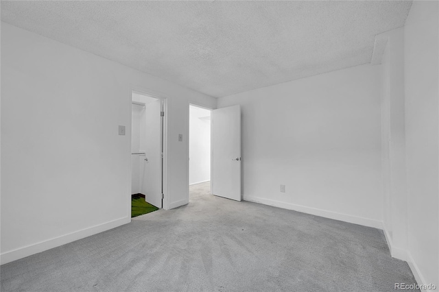 carpeted spare room featuring a textured ceiling