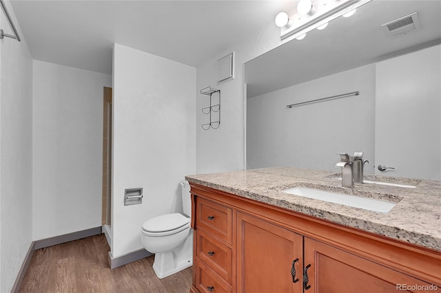 bathroom with hardwood / wood-style flooring, vanity, and toilet