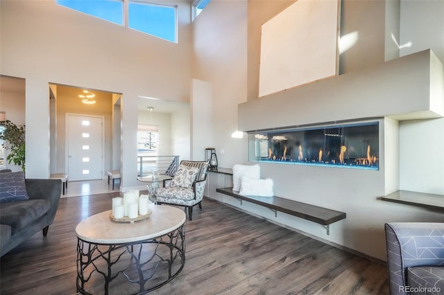 living room featuring wood finished floors and a towering ceiling