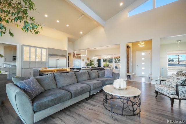 living area with recessed lighting, beamed ceiling, high vaulted ceiling, and wood finished floors