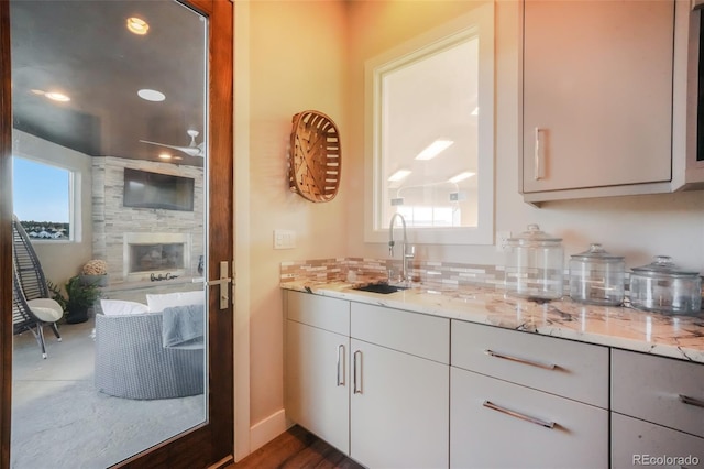 bathroom featuring tasteful backsplash, a wealth of natural light, and a sink