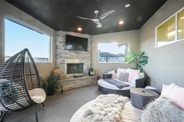 interior space with a stone fireplace, recessed lighting, and a ceiling fan