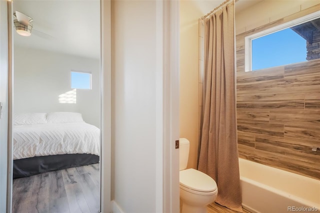 full bath featuring wood finished floors, toilet, ensuite bath, and shower / tub combo