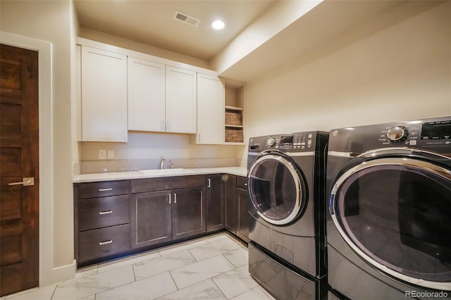 laundry room featuring washing machine and clothes dryer, visible vents, cabinet space, marble finish floor, and a sink