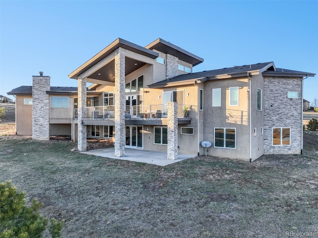 rear view of property with a patio area, a lawn, and stucco siding