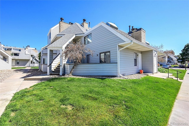 view of home's exterior with stairway, a chimney, and a lawn