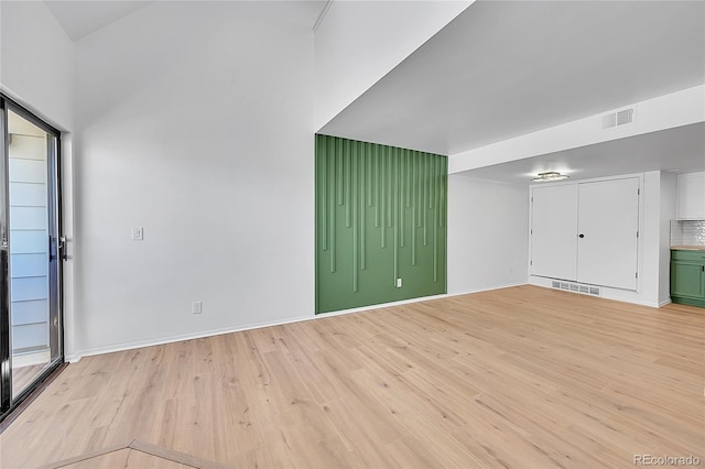 interior space featuring light wood-type flooring, visible vents, and baseboards