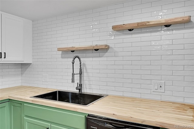 kitchen featuring a sink, green cabinetry, butcher block counters, open shelves, and backsplash