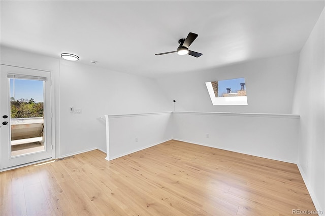 unfurnished room with a ceiling fan, baseboards, and light wood-style flooring