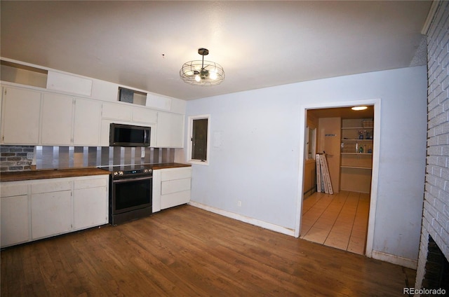 kitchen featuring wood-type flooring, white cabinetry, backsplash, hanging light fixtures, and electric range oven