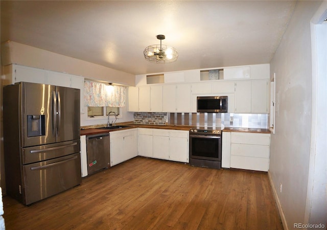 kitchen featuring stainless steel appliances, dark hardwood / wood-style floors, and white cabinets