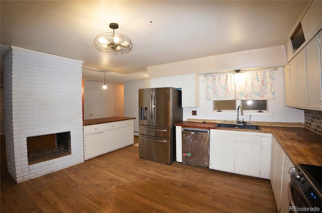 kitchen featuring white cabinets, appliances with stainless steel finishes, and wooden counters