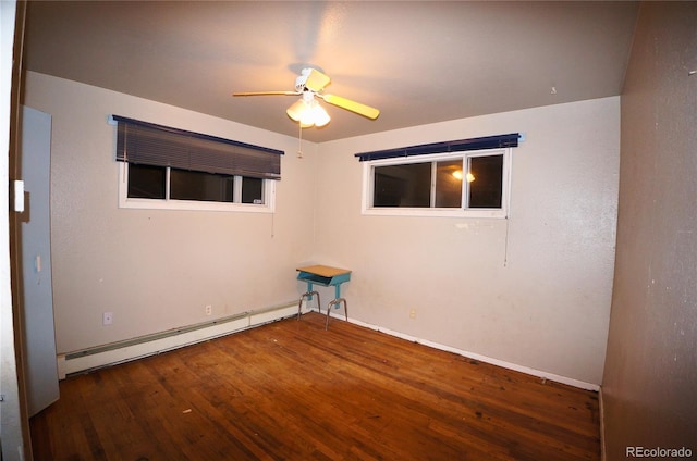 empty room featuring ceiling fan, dark hardwood / wood-style floors, and a baseboard heating unit