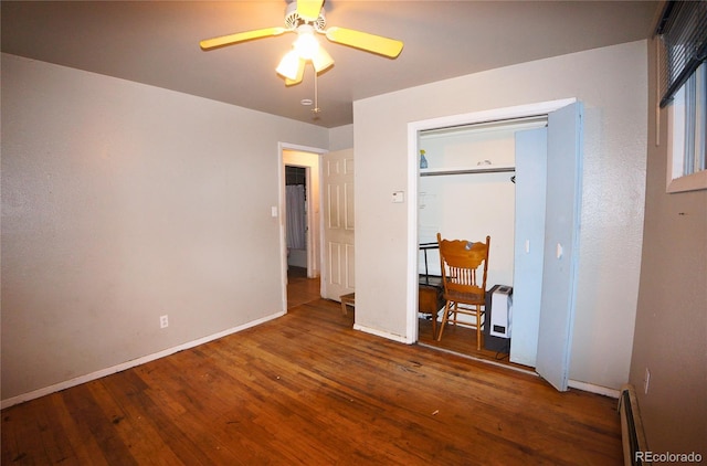 bedroom featuring ceiling fan, wood-type flooring, and a baseboard heating unit