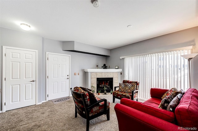 carpeted living room featuring a tile fireplace