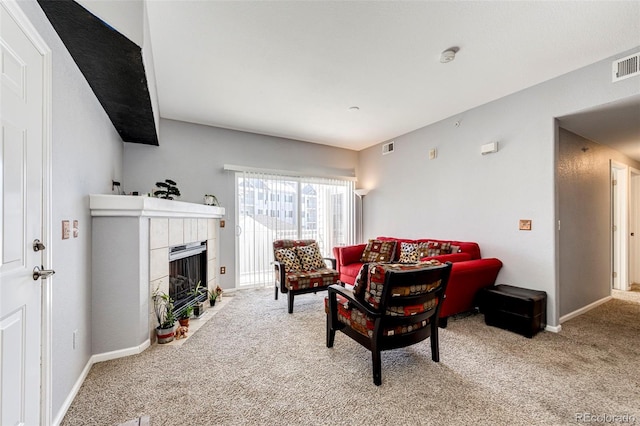 carpeted living room with a tile fireplace