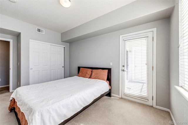 carpeted bedroom with a closet and multiple windows