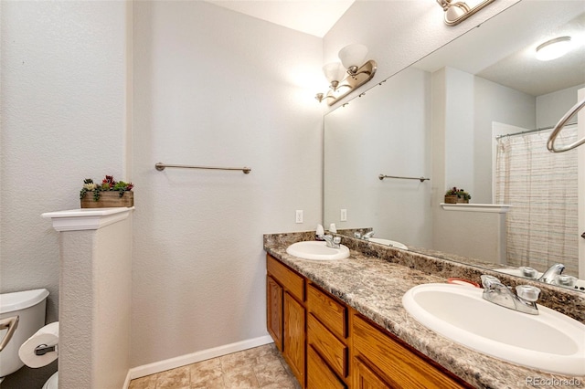 bathroom featuring double sink vanity, toilet, and tile floors