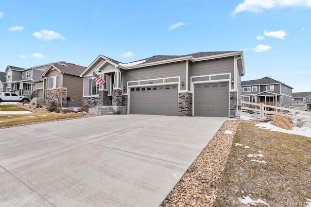 view of front facade featuring a garage, stone siding, fence, and a residential view