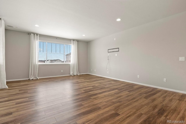 spare room featuring dark wood-style floors, baseboards, and recessed lighting