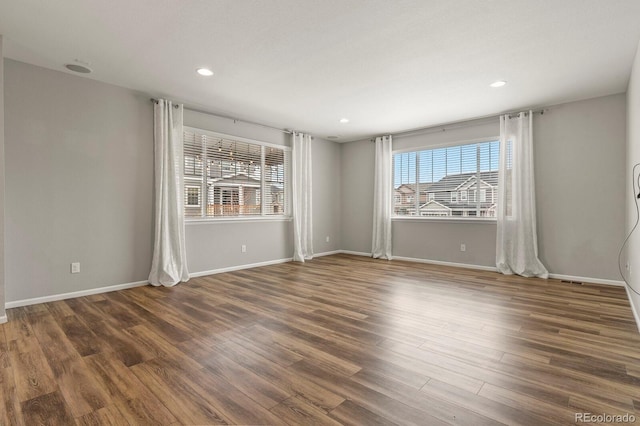 spare room featuring recessed lighting, baseboards, and wood finished floors